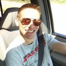 Paul wearing sunglasses and a giant smile